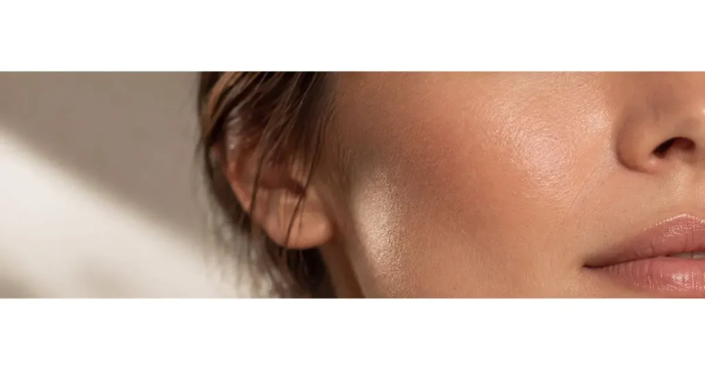 Close da pele do rosto de uma mulher com textura natural e aparência luminosa