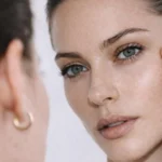 Mulher observando o reflexo no espelho com foco no olhar